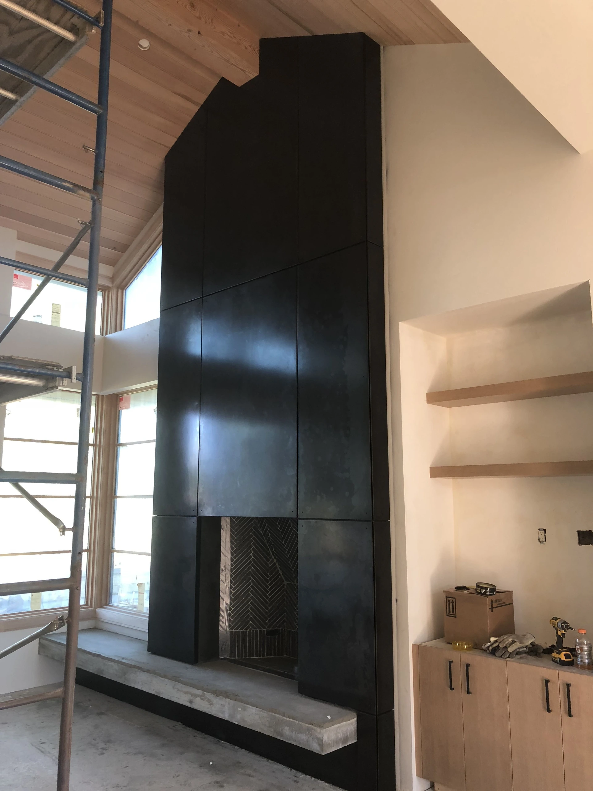 floor to ceiling dark sheet metal fireplace surround custom fabrication